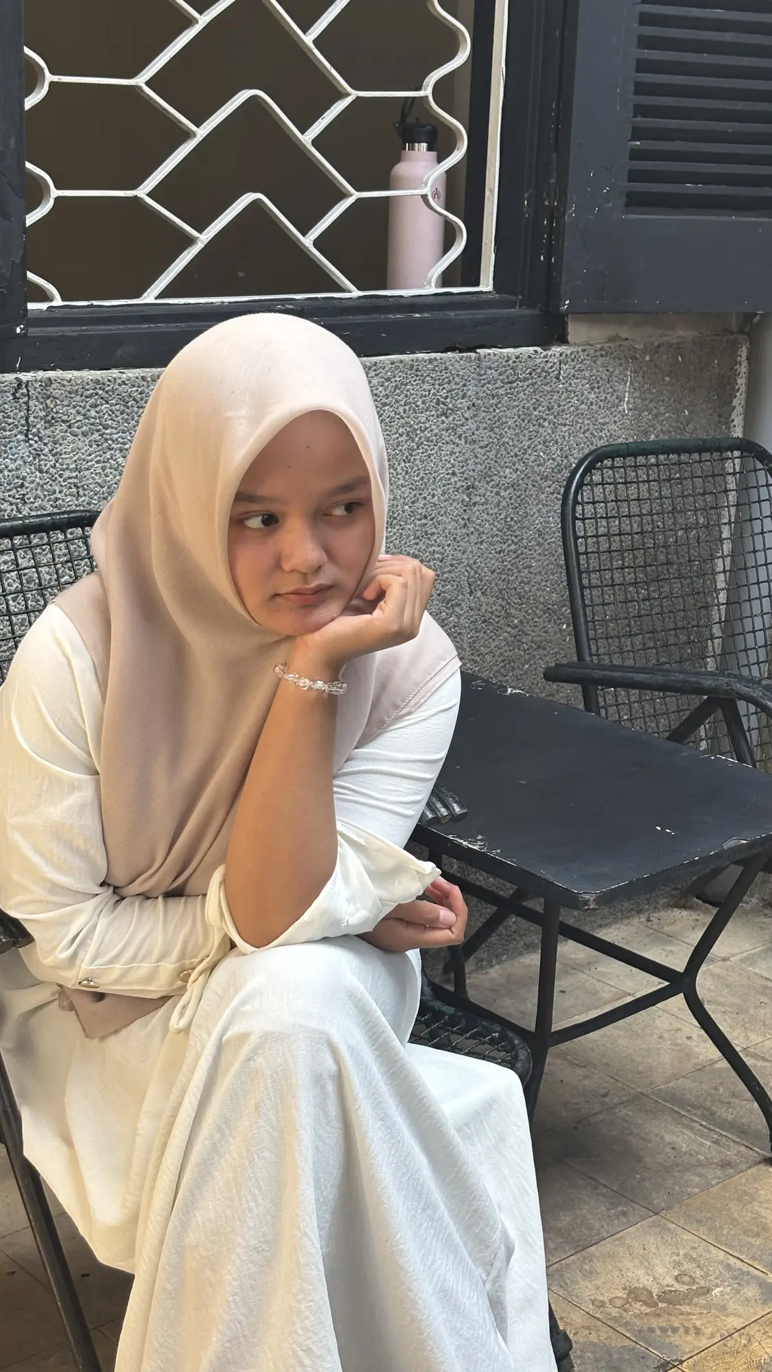 Cantika mengenakan pakaian putih dan duduk santai