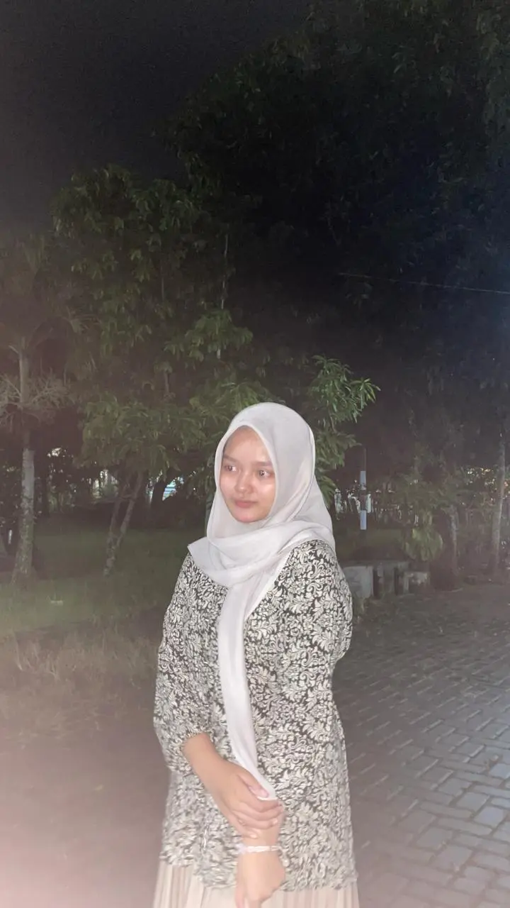 Cantika berdiri di luar ruangan pada malam hari